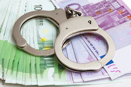 Foto: Handschellen und Euro Banknoten Handschellen und Euro Banknoten