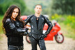 two young people against red motorbike