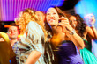 Party people dancing in disco or club