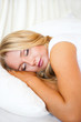 Portrait of young beautiful sleeping woman on bed at bedroom