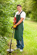 Gardener with lawn trimmer