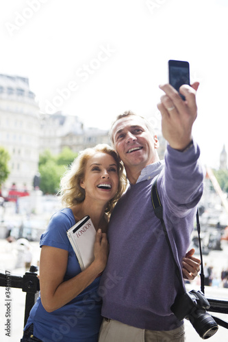 Photo: A middle-aged couple standing by Trafalgar Square A middle-aged couple standing by Trafalgar Square
