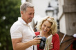 A middle-aged couple looking at photographs on their camera