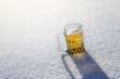 A glass of beer sitting in snow