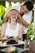 Man covering woman's eyes