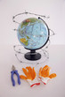 Globe tangled in barbed wire with pliers and a pair of gloves on the table