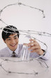 Man taking plastic water bottle from inside coiled barbed wire