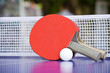 Two table tennis or ping pong rackets and balls on a blue table