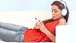 Young girl lying on couch listen to the music with headphones