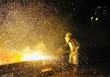 worker using torch cutter to cut through metal