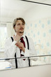 Man adjusting cuff link while looking at the mirror