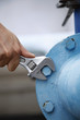 Spanner tightening bolt on a pipe