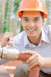 Smiling young worker repairing a pipe