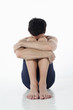 Man sitting on the floor hugging his knees