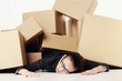 Businesswoman lying unconsciously on the floor after being buried under a pile of boxes