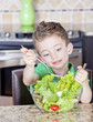 Young boy making salad