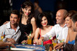 laughing friends playing cards in casino