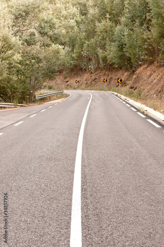 Photo: Empty asphalt road trought hills against Woods Empty asphalt road trought hills against Woods