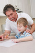 Middle aged father helping young son with homework