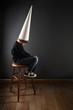 Child wearing a dunce cap