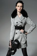 fashion model in autumn/winter clothes holding handbag posing