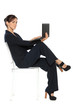 Full lenth of businesswoman sitting in chair with laptop