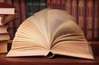 Pile of books with reading glasses on desk