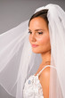 beautiful bride under veil on studio neutral background