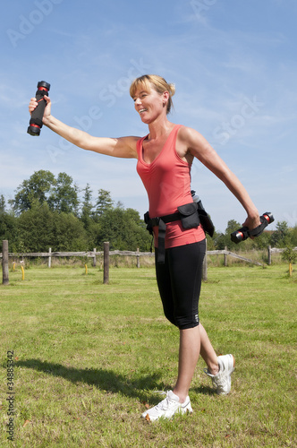 Foto: Sportliche Frau beim Schwunghanteltraining Sportliche Frau beim Schwunghanteltraining