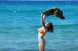 Beautiful young woman on the beach with a colored tissue