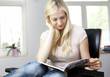 young woman reads a book in her living room