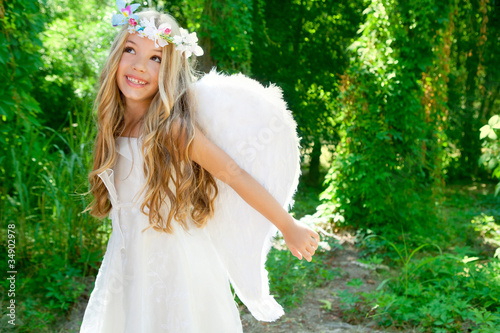Photo: Angel children girl open arms in forest white wings Angel children girl open arms in forest white wings
