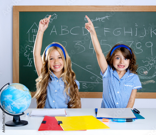 Photo: clever students in classroom raising hand clever students in classroom raising hand
