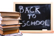 back to school written on chalkboard with books