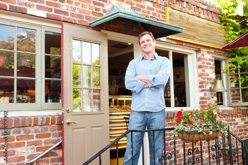 Photo: Man standing outside bakery/café Man standing outside bakery/café