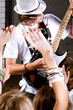 Guitarist performing in front of a cheering crowd