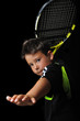 Tennis boy playing forehand isolated in black