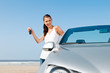 Frau mit Auto am Strand