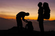 Silhouettes of two backpackers during a sunset