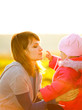 Happy mother with daughter enjoying a autumn day at the meadow