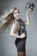Foto: Beautiful young blond woman dancing with disco ball Beautiful young blond woman dancing with disco ball