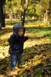Toddler playing in the park in autumn