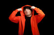 young man in orange sweatshirt, black background