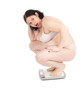 squats on scale young fat woman in underwear, series