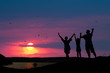 The family from three persons welcomes the sunset sun