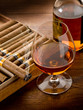 cuban cigar and bottle of cognac on wood background