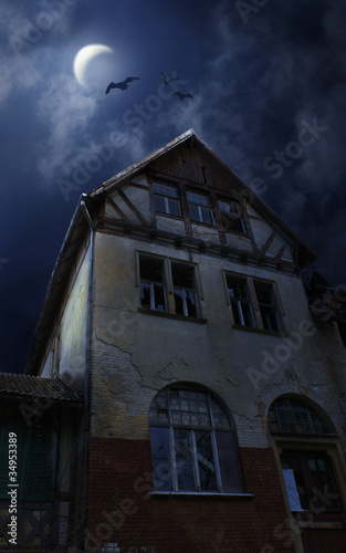 Photo: Sinister old house in Halloween night. Bats, Moon Sinister old house in Halloween night. Bats, Moon