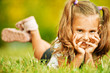 portrait of adorable little girl lying on grass