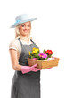 Young florist holding a basket with flowers