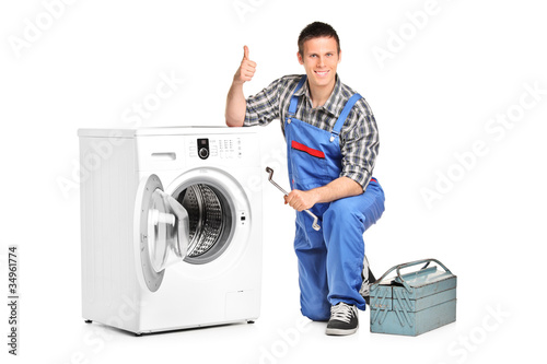 Photo: Repairman giving thumb up next to a washing machine Repairman giving thumb up next to a washing machine